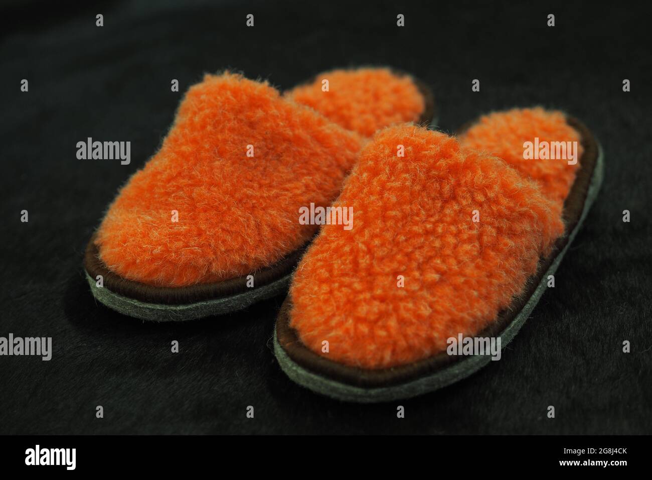 Bequeme Hausschuhe auf einem weichen Teppich. Das Konzept von Komfort, Wärme und Gemütlichkeit. Hochwertige Fotos Stockfoto
