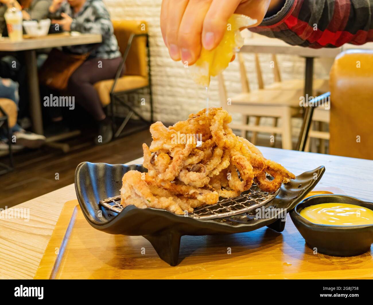 Nahaufnahme des Quetschens von Zitronensaft zu den Crispy Squid Tentakeln in Las Vegas, Nevada Stockfoto