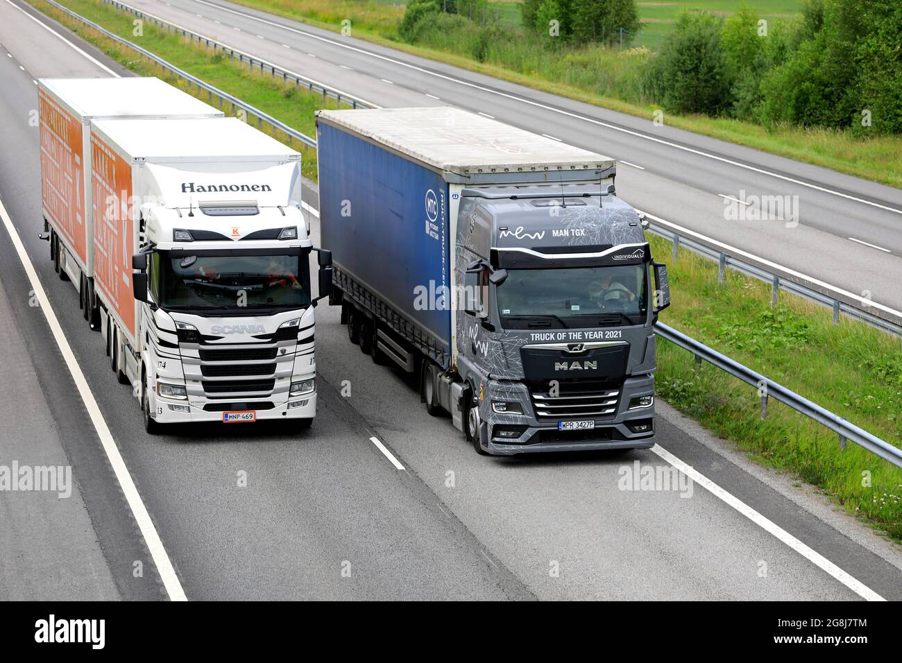 MAN TGX, International Truck des Jahres 2021, überholt vor dem Sattelauflieger den Scania R500 LKW auf der Autobahn. Salo, Finnland. 9. Juli 2021. Stockfoto