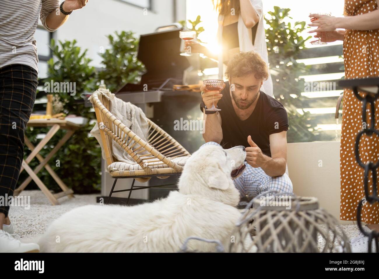 Freunde mit Hund und Getränke im Hinterhof Stockfoto