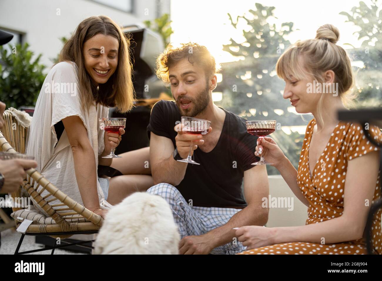 Freunde mit Hund und Getränke im Hinterhof Stockfoto