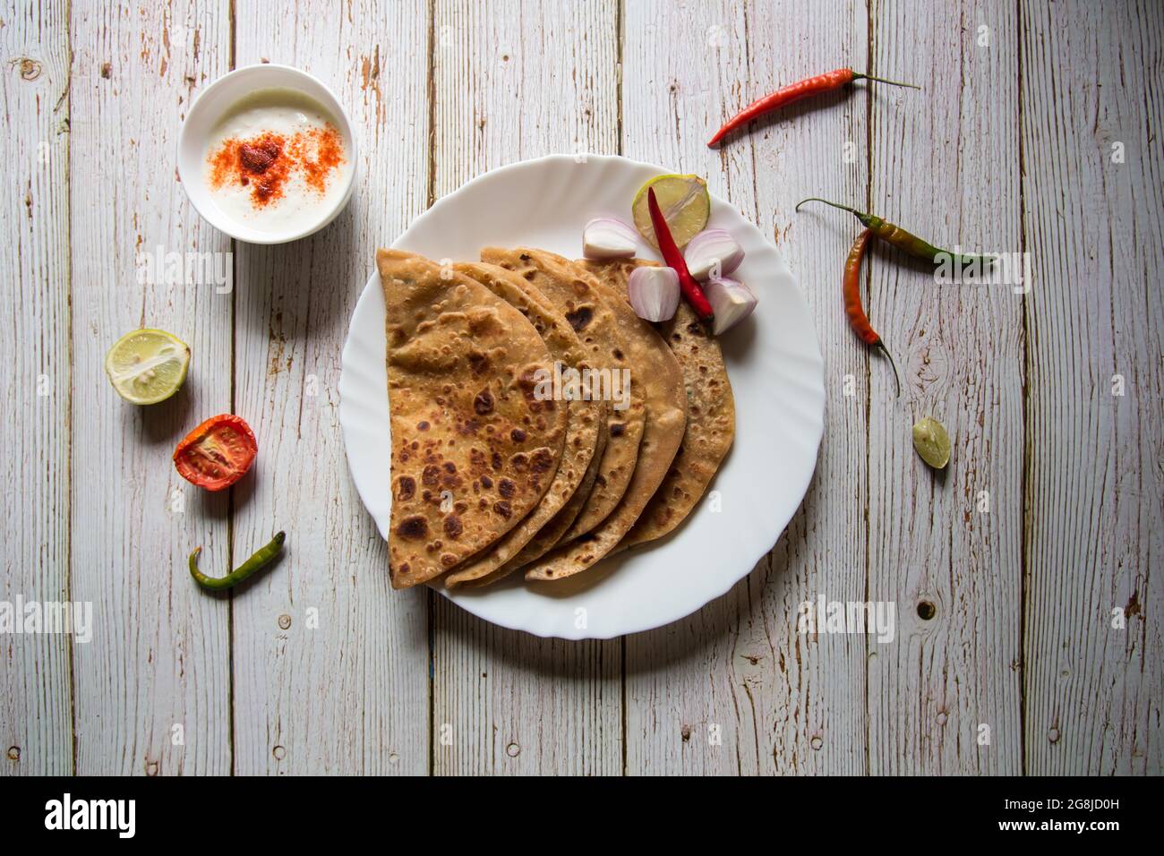 Gefüllte Kartoffel oder Aloo Paratha serviert mit Gewürzen und Quark. Ein indisches Frühstücksgericht. Stockfoto