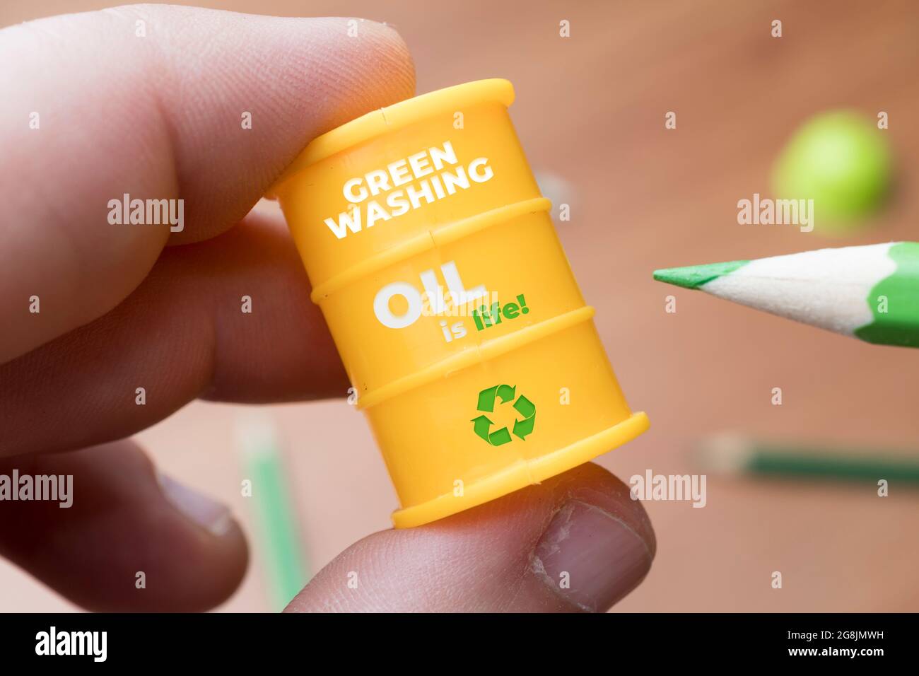Greenwashing-Konzept. Der Mensch malt ein Barrel Öl mit einem grünen Bleistift. Greenwashing ist eine Kommunikationstechnik, die darauf abzielt, ein falsches Bild eines c zu erstellen Stockfoto