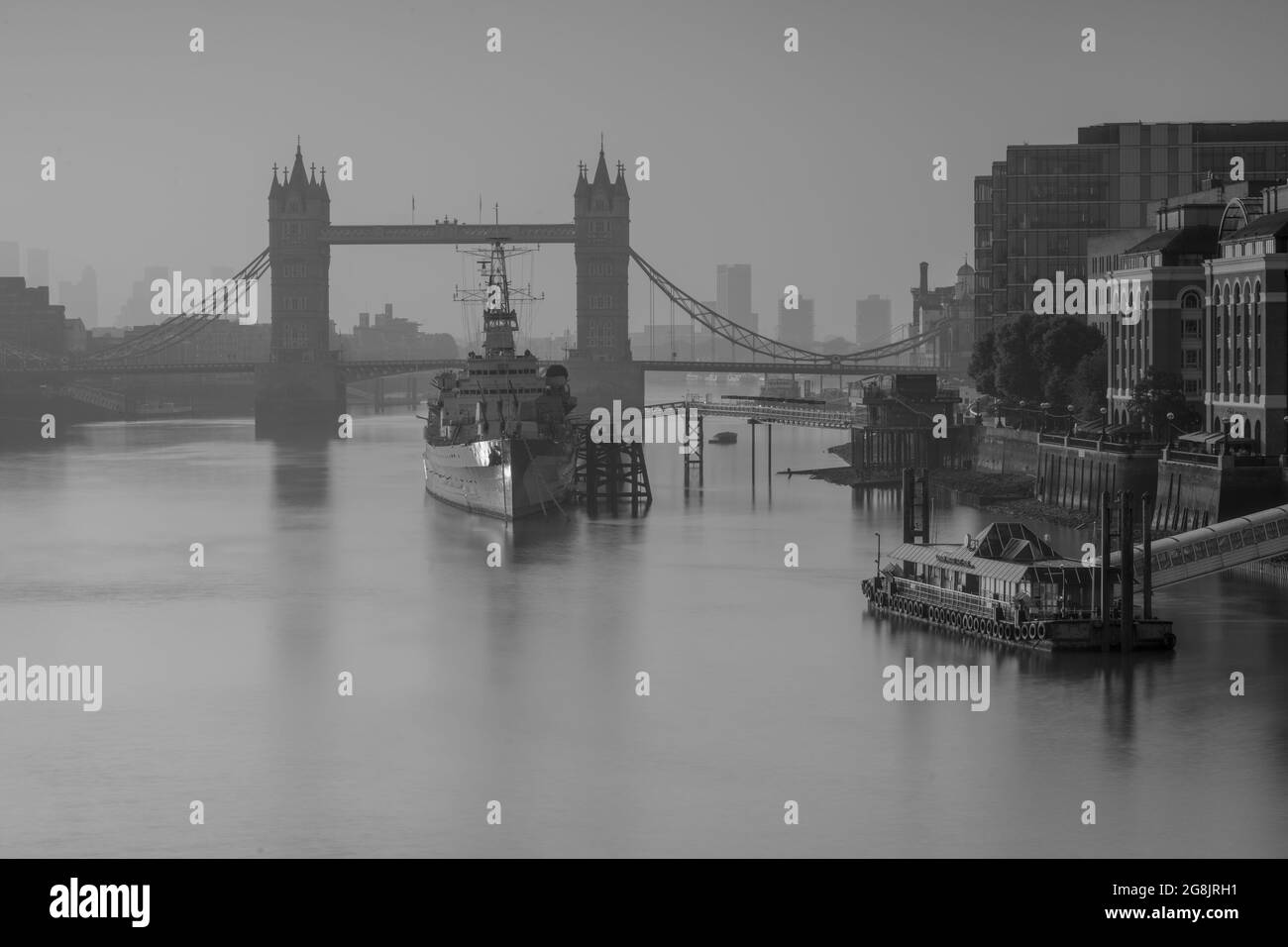 City of London, Großbritannien. Juli 2021. Wetter in Großbritannien: Wunderschöner, trüber Sonnenaufgang über der Tower Bridge, der City of London und der HMS Belfast, als die Hauptstadt während der Hitzewelle zu einem weiteren Tag mit herrlichem Sonnenschein und klarem Himmel aufwacht. Kredit: Celia McMahon/Alamy Live Nachrichten Stockfoto