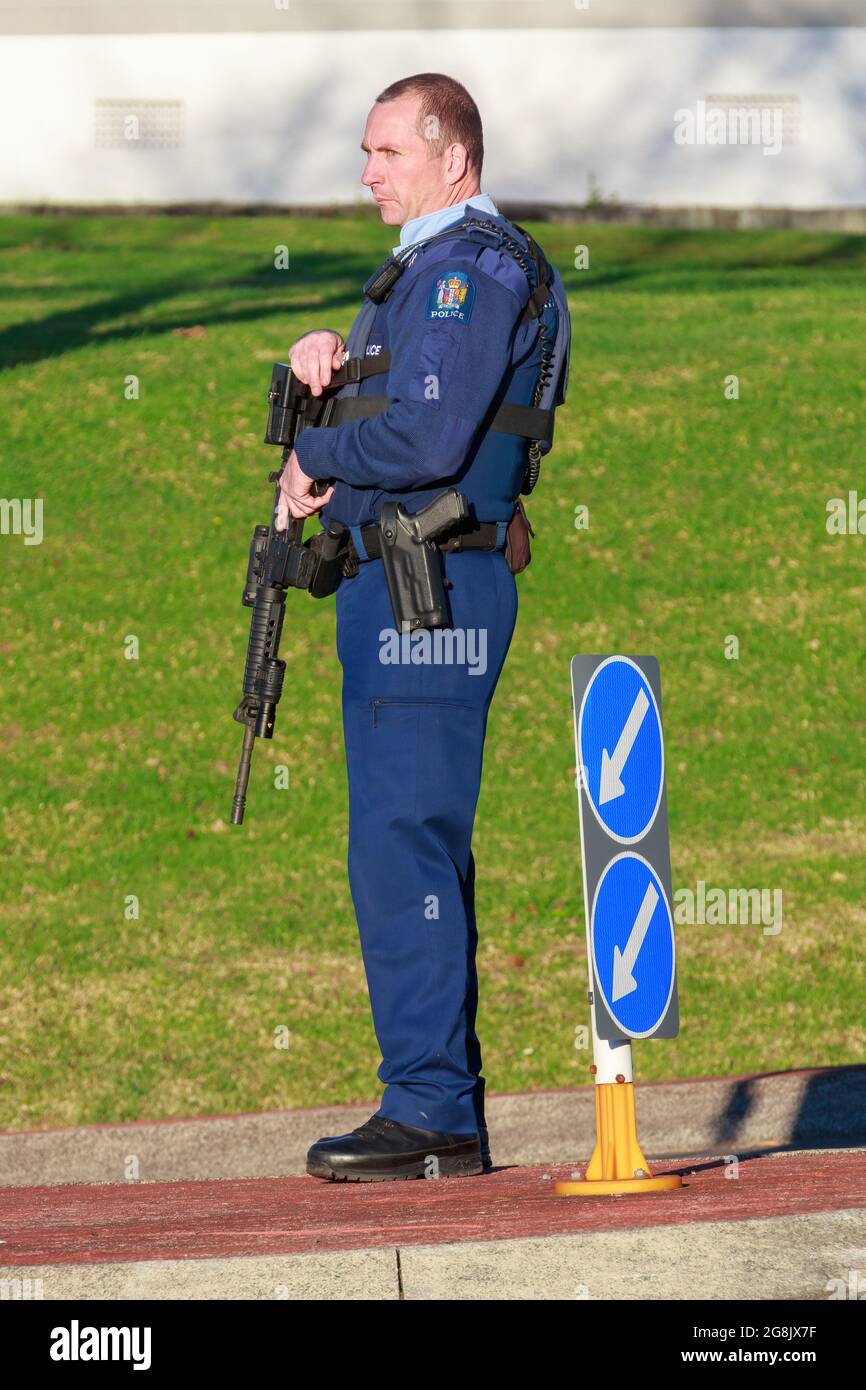 Ein neuseeländischer Polizeibeamter, der mit einem halbautomatischen Gewehr bewaffnet ist und eine Straße bewacht Stockfoto