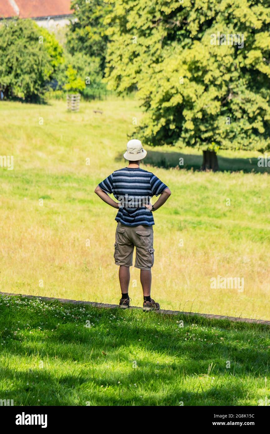 Mann mit Hut und Händen auf Hüften genießt die Parklandschaft um Hughenden Manor, High Wycombe Stockfoto