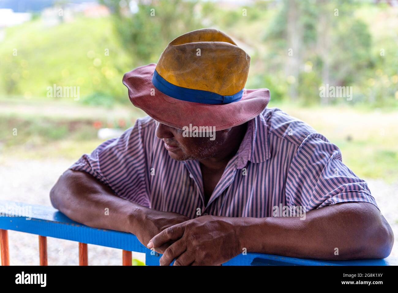 Porträt eines kolumbianischen Bauern, der sich an ein Holzgeländer lehnt Stockfoto