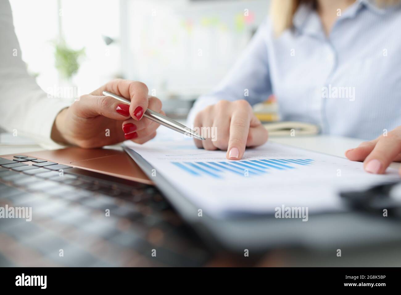 Weibliche Marketingfachleute, die in Geschäftsdiagrammen berichten Stockfoto