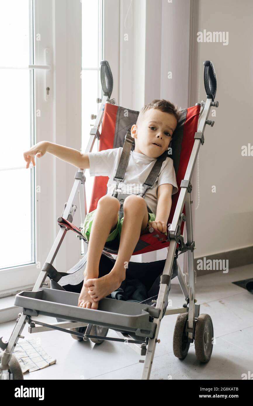 Junge mit zerebrannem Palsy in einem speziellen Stuhl, der an der Tür nach  draußen geht. Barrierefreiheit für behinderte Menschen in Kinderwagen  Stockfotografie - Alamy