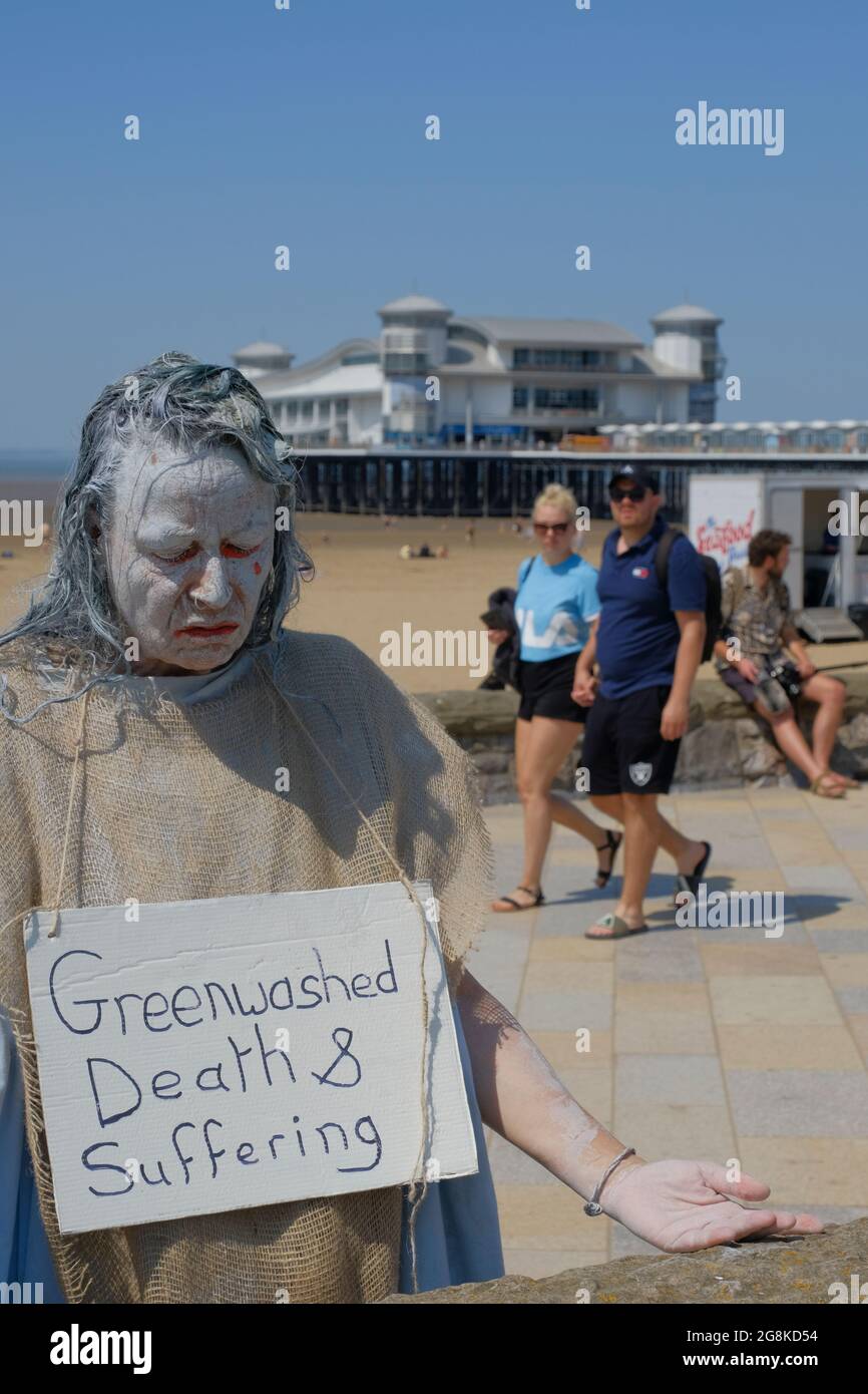 Weston-super-Mare, Somerset, Großbritannien. Juli 2021. In Weston-super-Mare werden Planungsvorschläge zur Erweiterung des Flughafens Bristol diskutiert. Die Demonstranten setzen sich aus Gründen des Klimawandels gegen die Expansion ein, bauen auf Grüngürtel und zunehmenden Verkehr. Bristol Airport Expansion Group ist eine Dachorganisation für lokale Extinction Rebellion und Klimafolgen. Diese Gruppe nennt sich Penitence und zwei Passanten sehen überrascht aus. Stockfoto