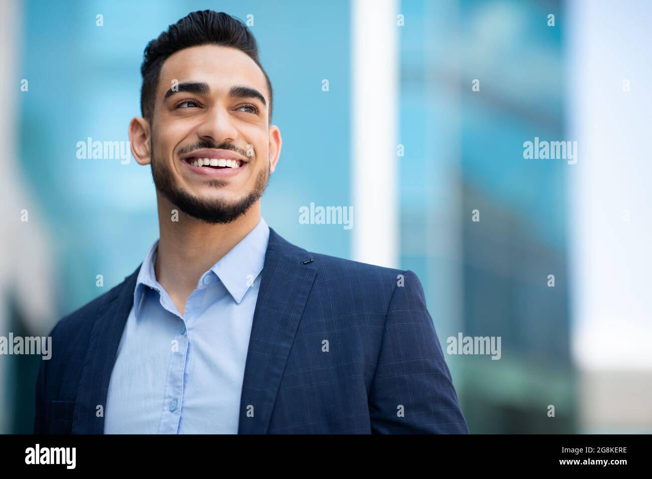 Wohlhabender arabischer Mann im Anzug, der den Kopierraum betrachtet Stockfoto