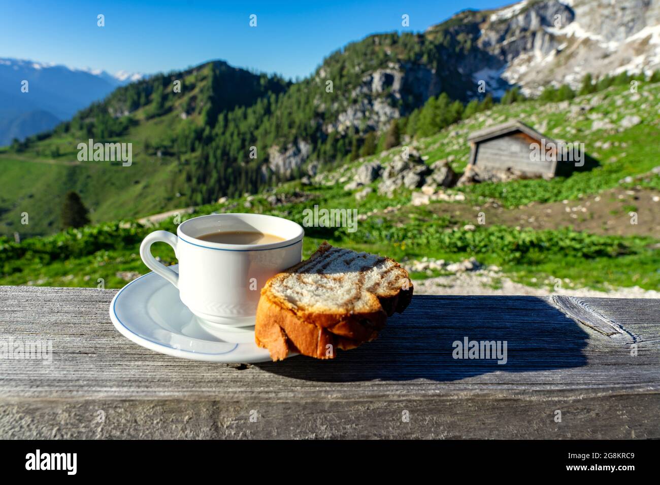Trinken einer Tasse caffee mit Frühstück über die Berge in Tirol auf einer Hütte Terrasse Stockfoto