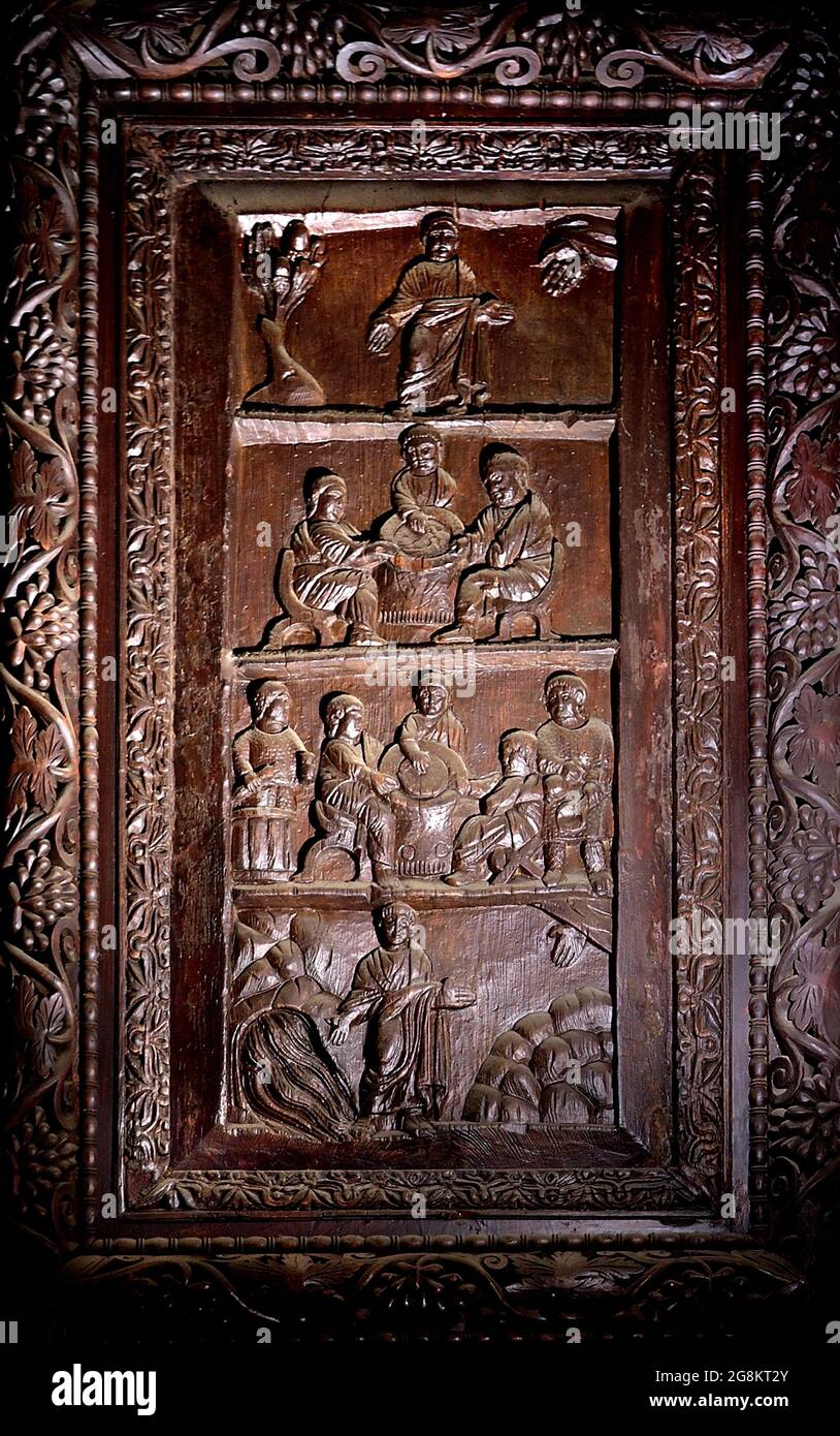 Rom Colle Aventino, Basilika Santa Sabina .insbesondere das große geschnitzte Zypressenportal, das aus dem 5. Jahrhundert stammt und perfekt erhalten ist, das erste Beispiel der christlichen Holzskulptur. Die achtzehn Tafeln, aus denen sie besteht, sind wirklich außergewöhnlich und stellen Szenen aus dem Alten und Neuen Testament dar. Man kann deutlich sehen, wie zwei verschiedene Künstler in der Tür arbeiten, einer ist klassizistischer mit einem hellenistischen Stempel, der andere hat Darstellungen von Volkskunst geschnitzt, darunter das erste erhaltene Bild von Christus, der zwischen den beiden Dieben gekreuzigt wurde. Geht und sucht die Szene des Durchgangs von Stockfoto