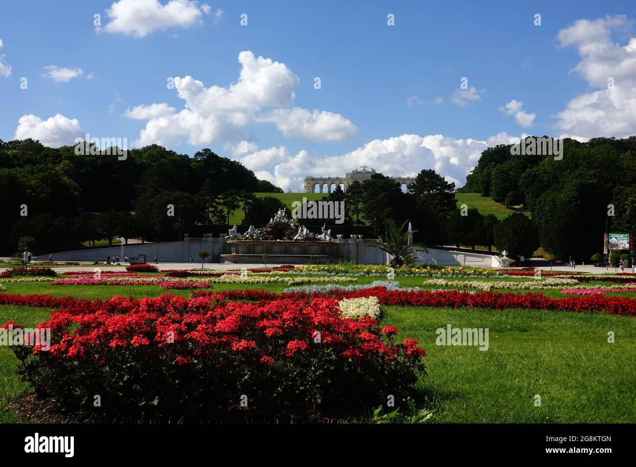 Wien, Österreich - Blick vom Schloss Schönbrunn in Richtung Neptunbrunnen und Gloriette über herrliche Blumen und Parkanlagen Stockfoto