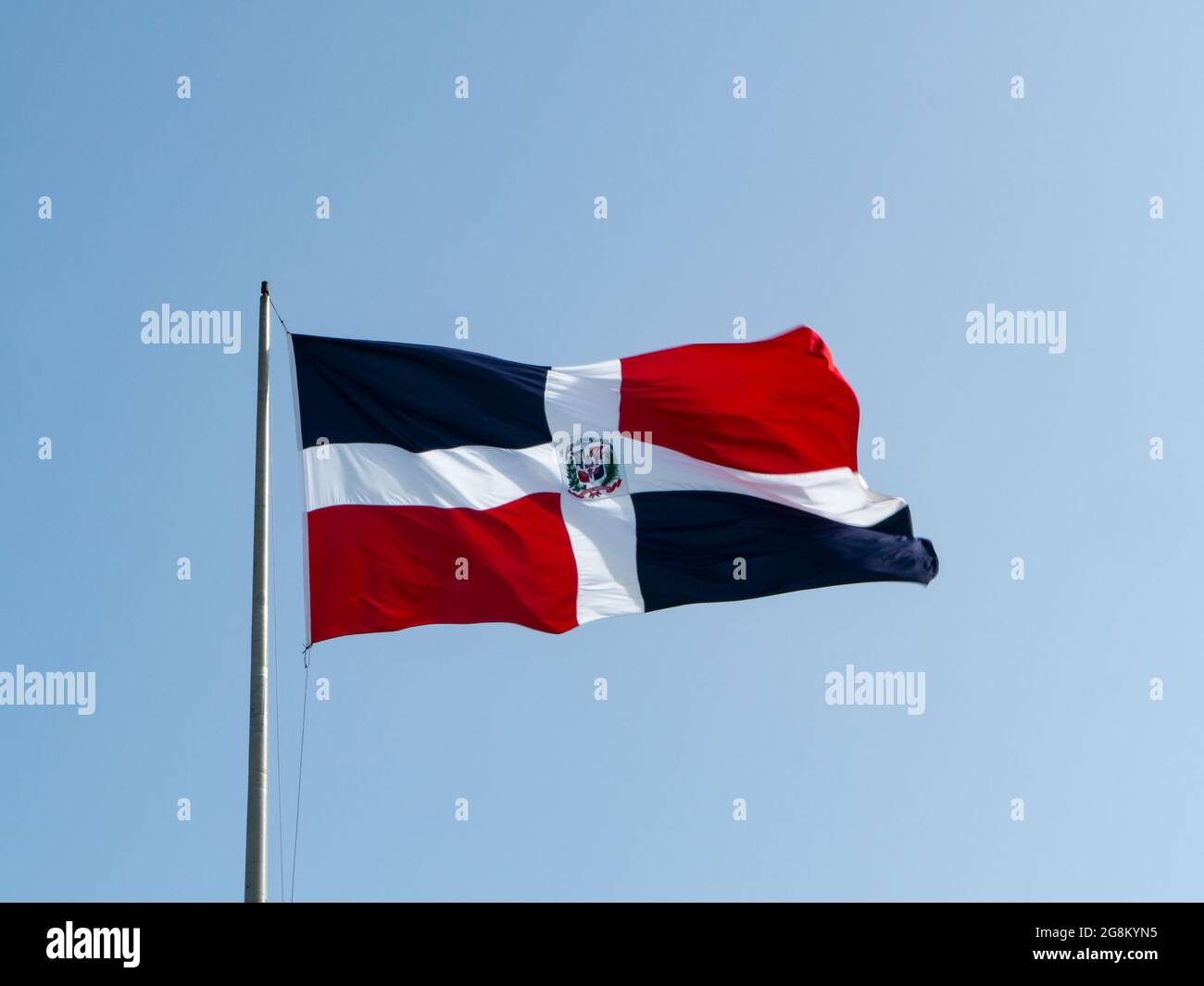 Die Dominikanerfahnen winken mit blauem Himmel im Hintergrund Stockfoto