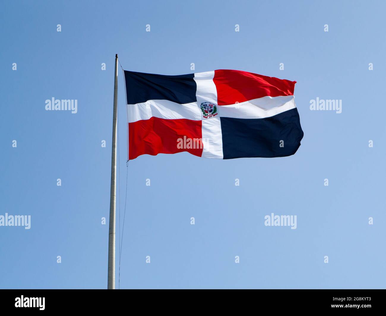 Die Dominikanerfahnen winken mit blauem Himmel im Hintergrund Stockfoto