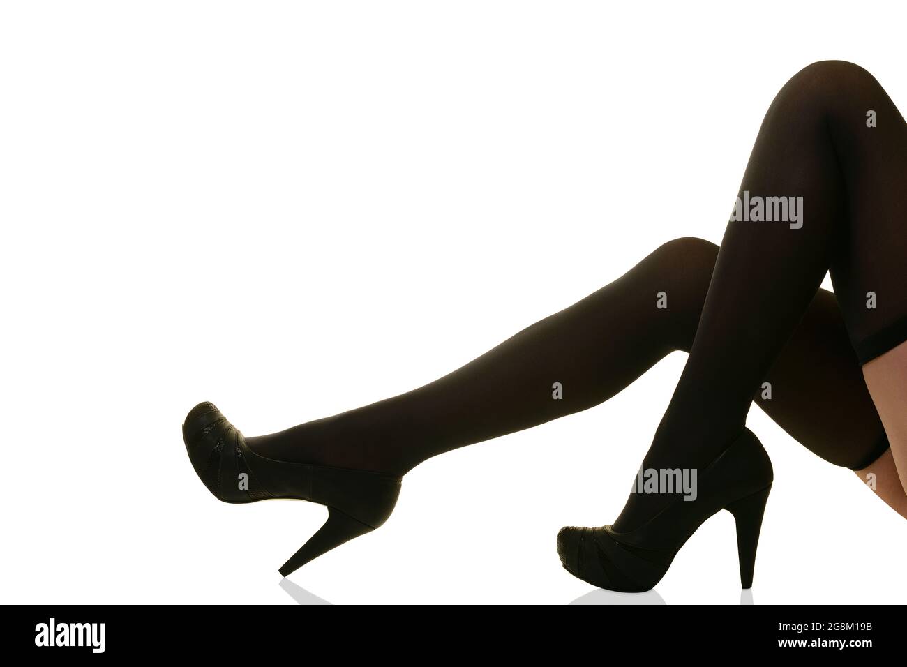 Weibliche Beine in schwarzen Strümpfen und Fersen Stockfoto