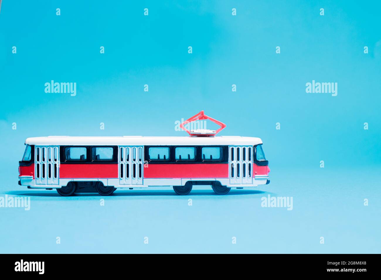 Kinderspielzeug rot weiß Tram auf einem blauen Hintergrund Kopie Platz für Text. Spielzeug für einen Spielwarenladen, Autos für einen Jungen. Stockfoto