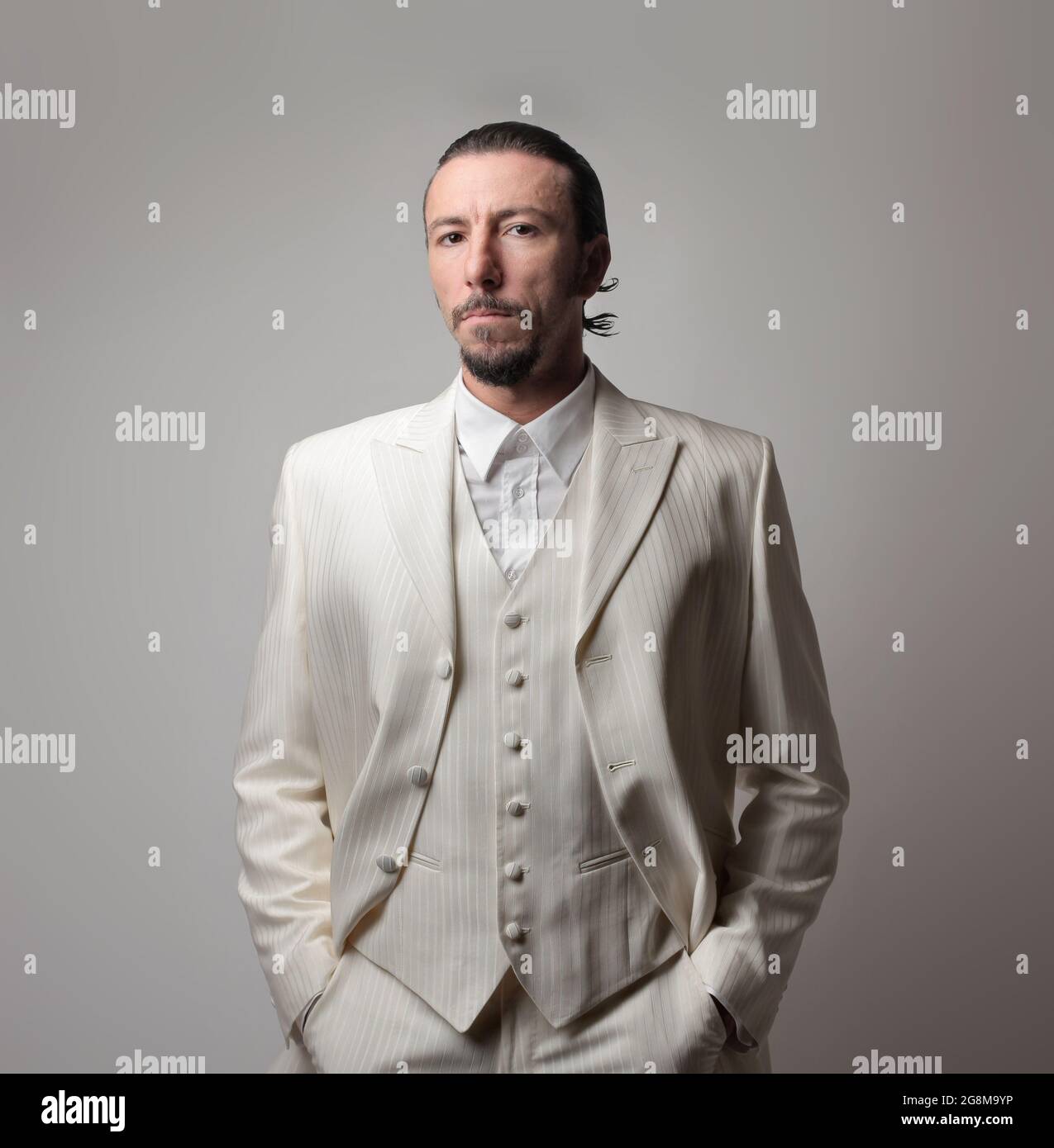 Porträt eines erwachsenen italienischen Mafia-Chefs in einem weißen Anzug  vor grauem Hintergrund Stockfotografie - Alamy