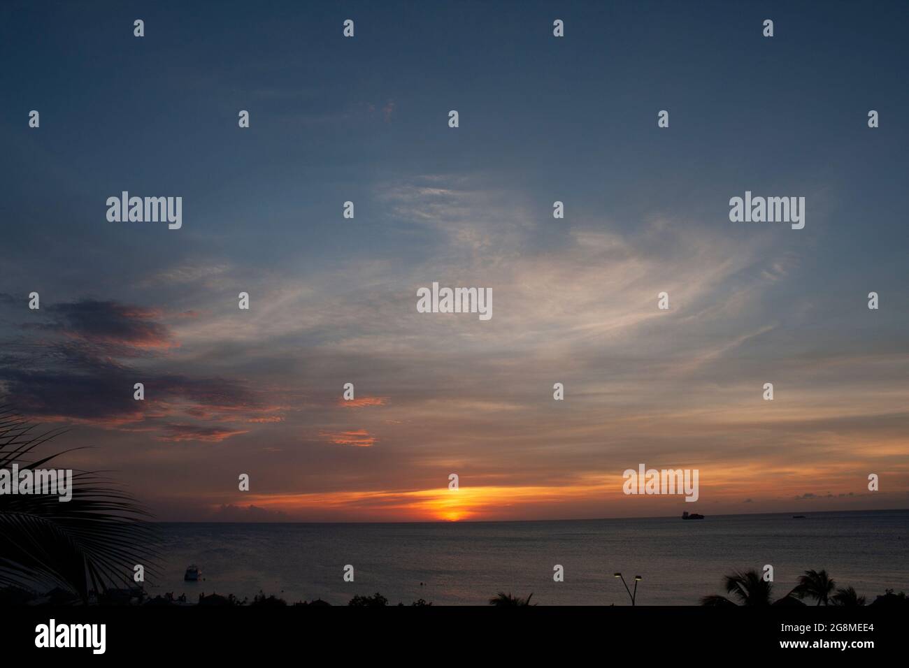 Sonnenuntergang am Strand von Aruba mit farbigem Himmel Stockfoto