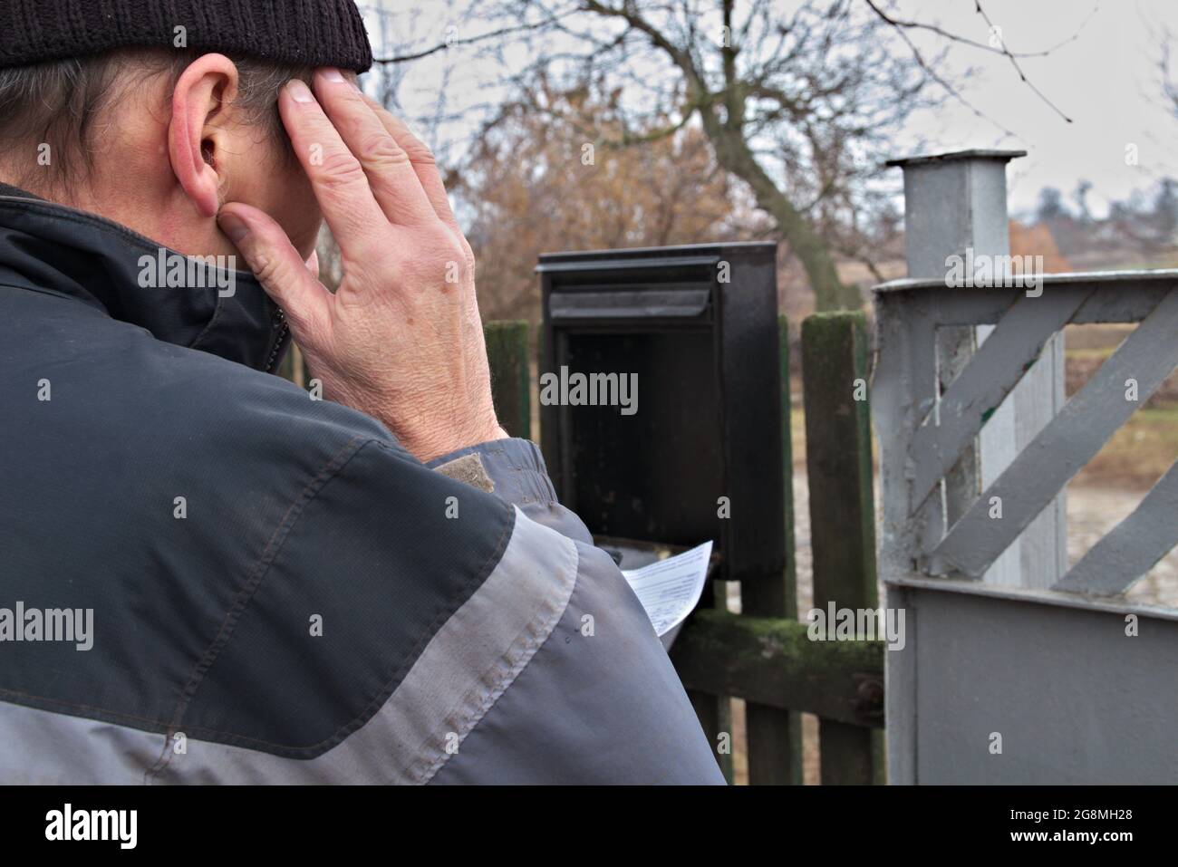 Ein alter Mann erhielt eine Rechnung für Strom oder Gas. Der Mann ist schockiert über den Preis. Stockfoto