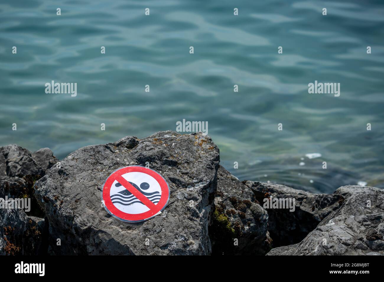 Kein Schwimmschild auf Felsen neben dem Wasser. Warnung. Stockfoto