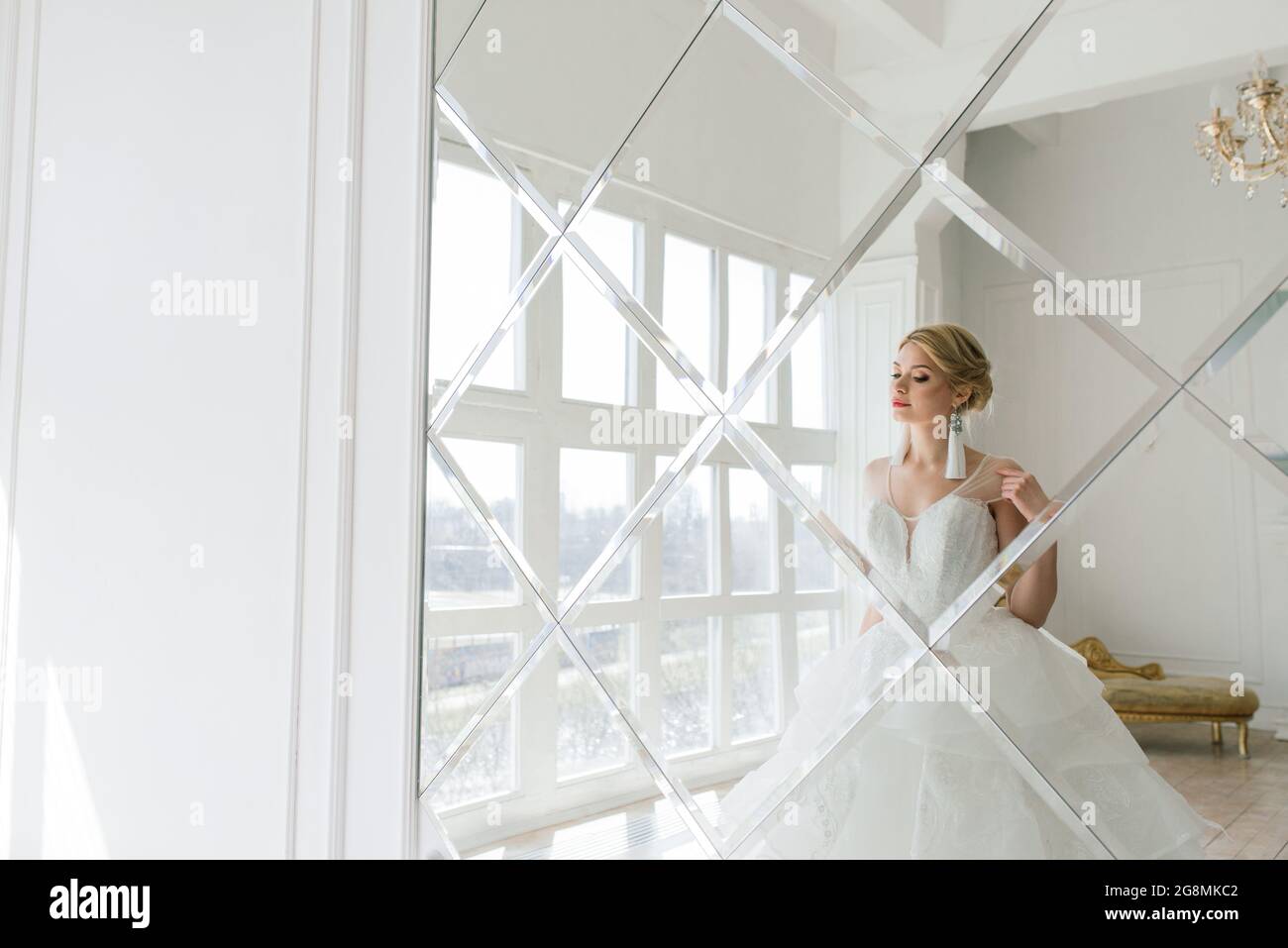 Kunstfoto einer sanften hübschen Frau mit blondem, Braut, wunderschönen teuren weißen Kleid Stockfoto