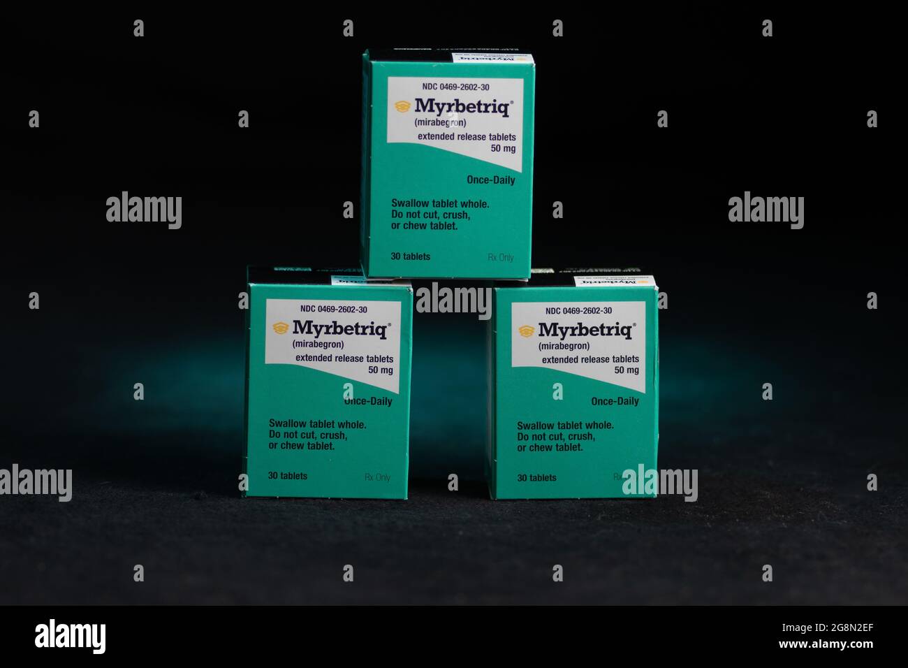 3 Boxen Myrbetriq verschreibungspflichtiges Medikament für Erwachsene zur Behandlung der überaktiven Blase (OAB) auf dunklem Hintergrund Stockfoto