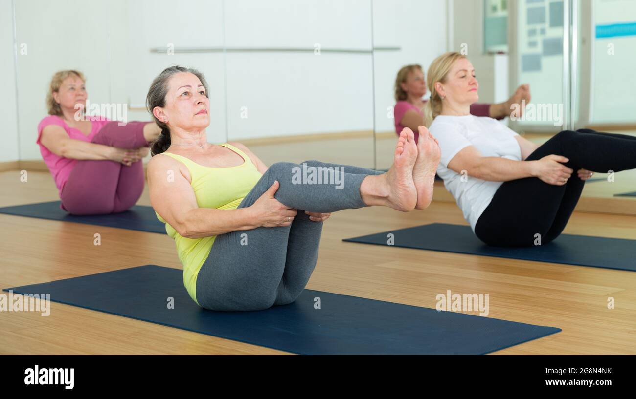 Menschen entspannen und genießen Yoga-Elemente - Boot Pose Stockfoto