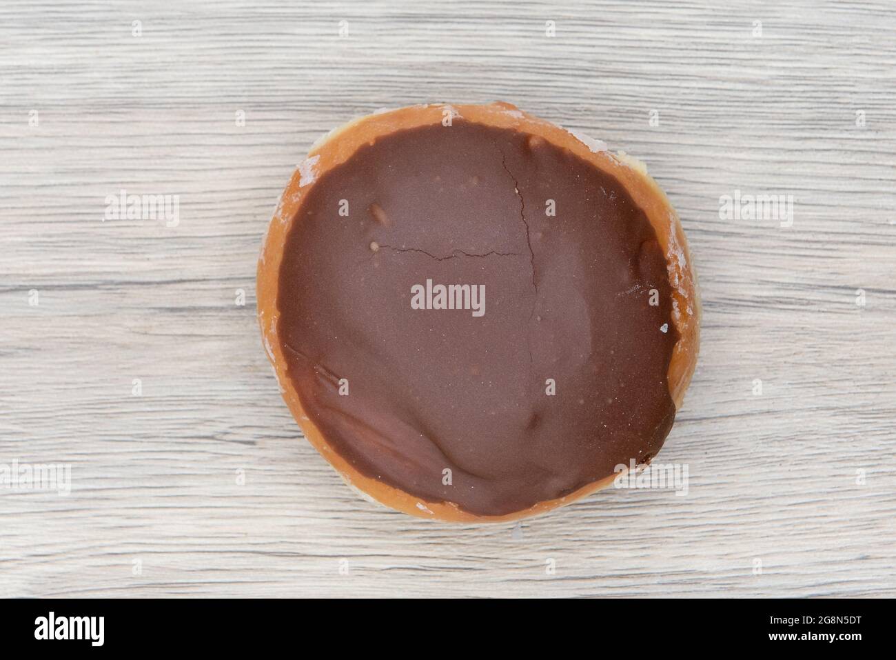 Der von oben aufgemotzte Donut ist mit einer Schokoladenbeschichtung versehen und sorgt so für einen süßen Genuss. Stockfoto