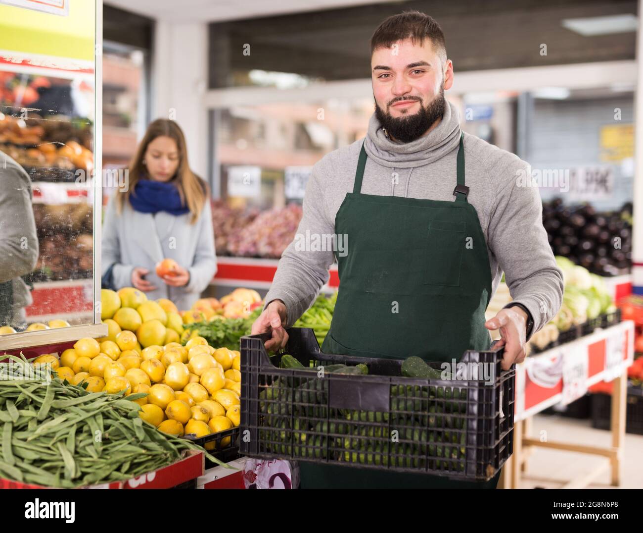 Positiver Mann, der mit Box Vegetarier auf dem Markt steht Stockfoto