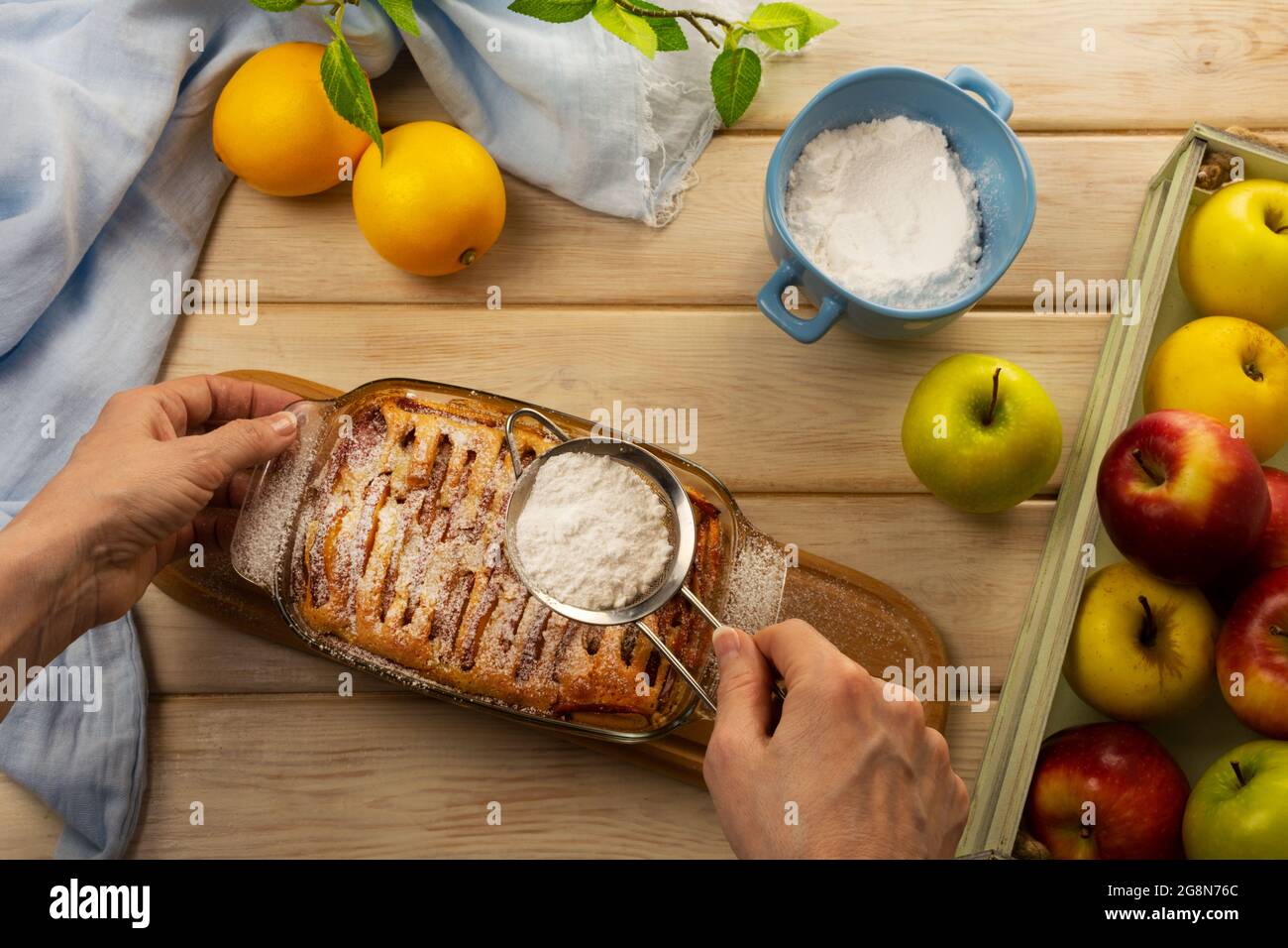 Frau schmückte Thanksgiving Apfelkuchen in Glasform mit Puderzucker Stockfoto