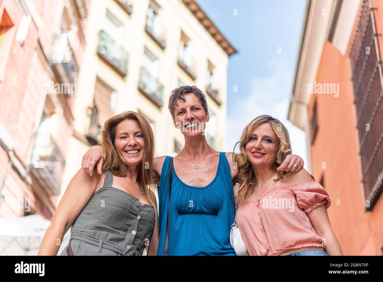 Drei fröhliche Erwachsene Frauen umarmen und betrachten die Kamera Stockfoto