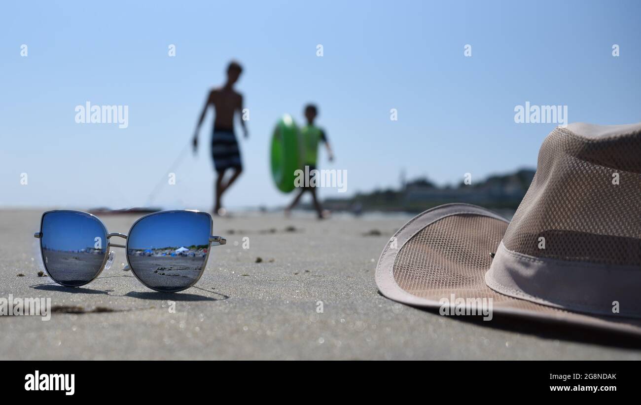 Jungs, die sich am Strand Vergnügen, während die Sonnenbrille andere lustige Gäste wiederspiegelt Stockfoto