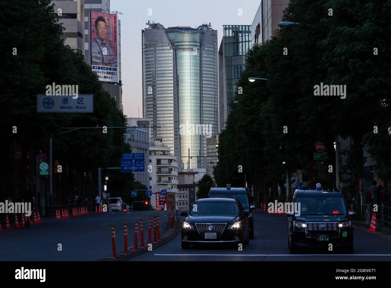Roppongi Hills Turm in der Dämmerung, mit Taxis auf einer Straße, vor. Aoyama Tokyo, Japan. Stockfoto