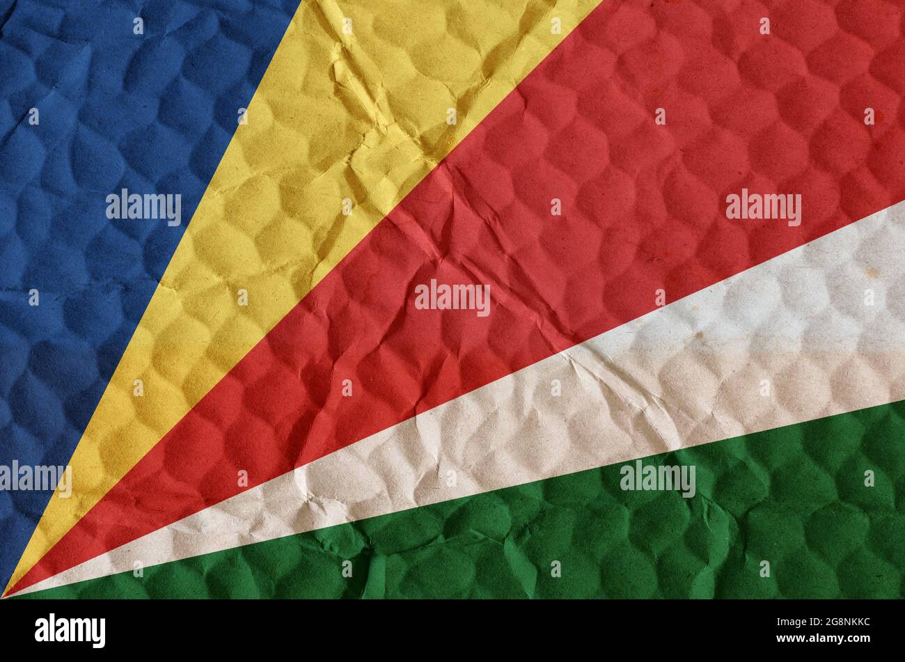 Bunte bunte Flagge der Republik Seychellen auf einer unebenen strukturierten Oberfläche. Die Nationalflagge des Inselstaates befindet sich in Ostafrika Stockfoto