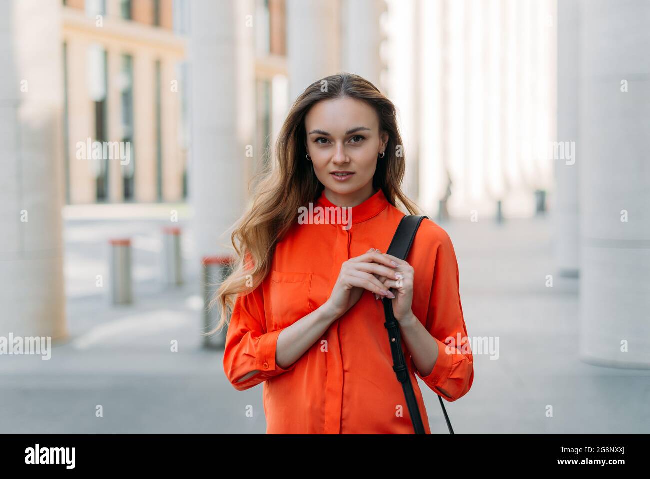 Schöne kaukasische Mädchen mit lockeren Haaren in der Stadt schaut auf die Kamera Stockfoto