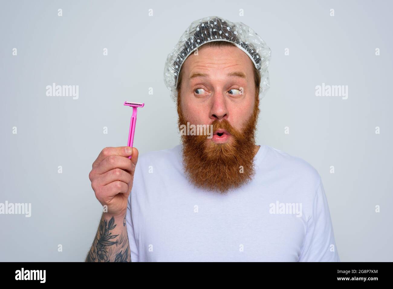 Wunderter Mann justiert den Bart mit einer Rasierklinge Stockfoto