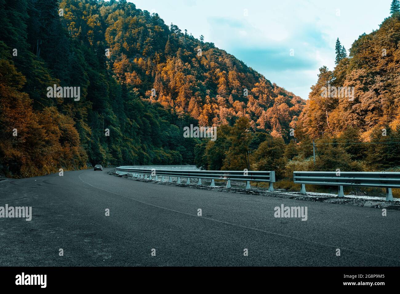 Herbst landschaftlich schöne Straße mit Straßentransport, dichter Wald mit Hügeln. Schöne Berg gekrümmte Straße, Stockfoto
