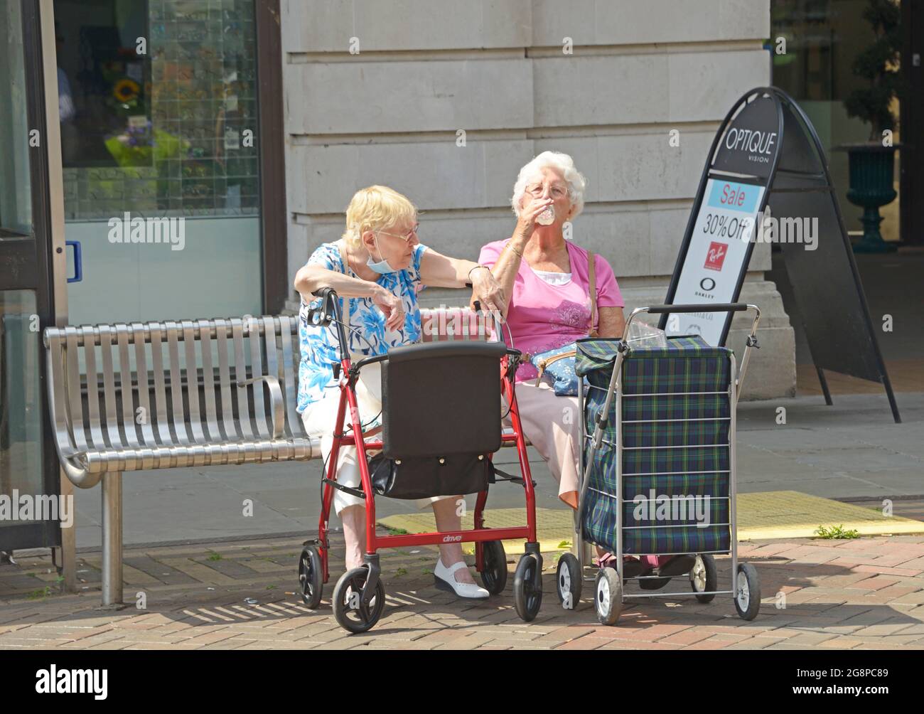 Zwei alte Damen mit Trolleys, die sich ausruhen. Stockfoto