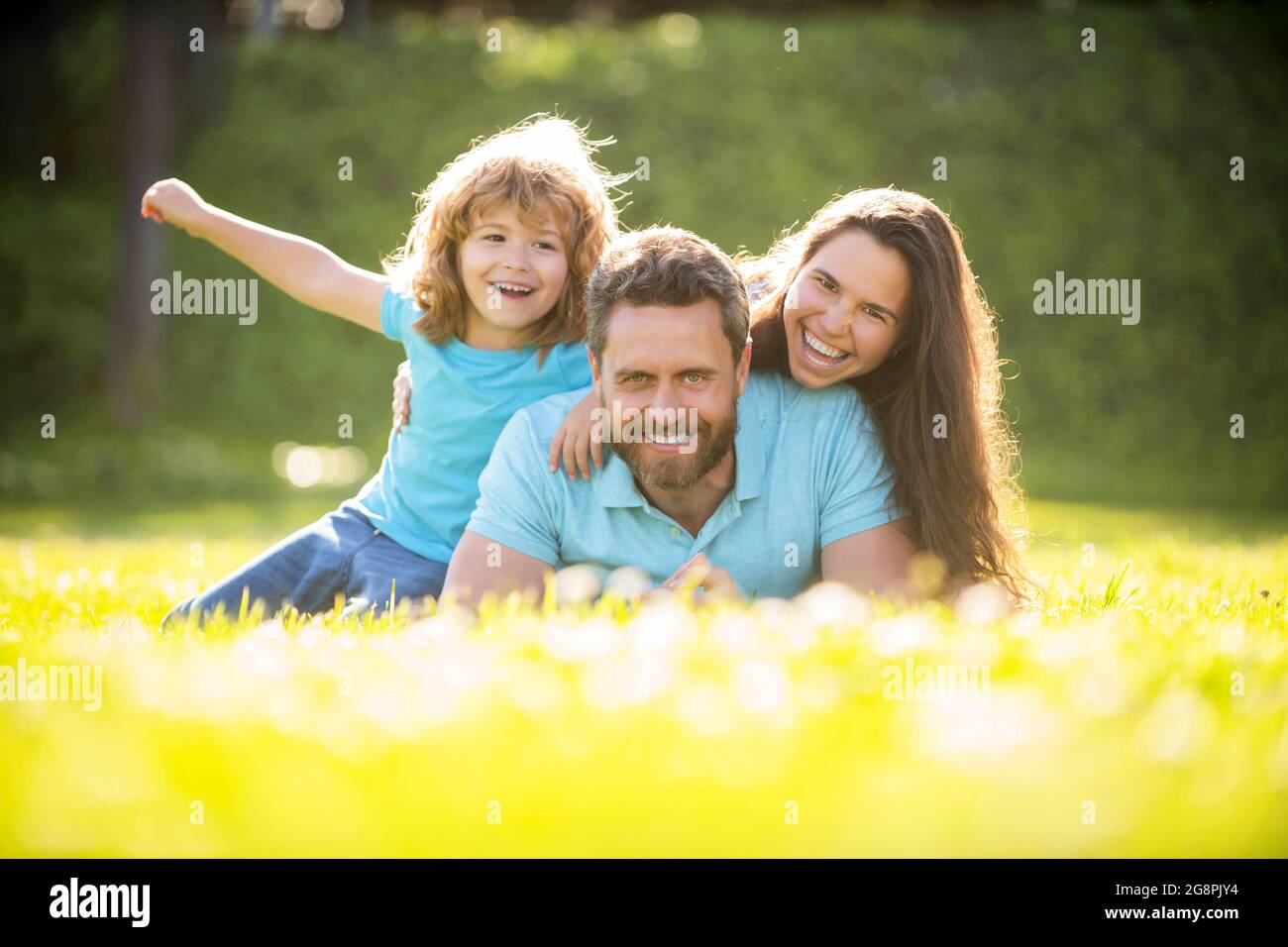Freundschaft. Vater Mutter und Kind auf grünem Parkgras. Freundliche Familie haben Spaß im Sommer Stockfoto