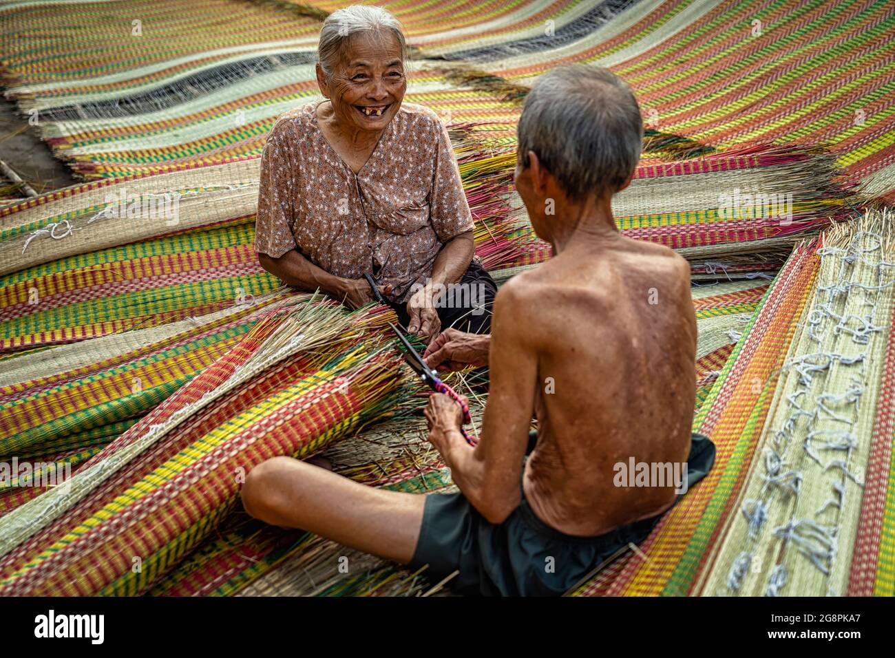 Draufsicht auf den alten vietnamesischen Liebhaber Handwerker, der die traditionellen vietnamesischen Matten mit Glücklichsein-Aktion im alten traditionellen Dorf dinh Yen, Dong, herstellte Stockfoto