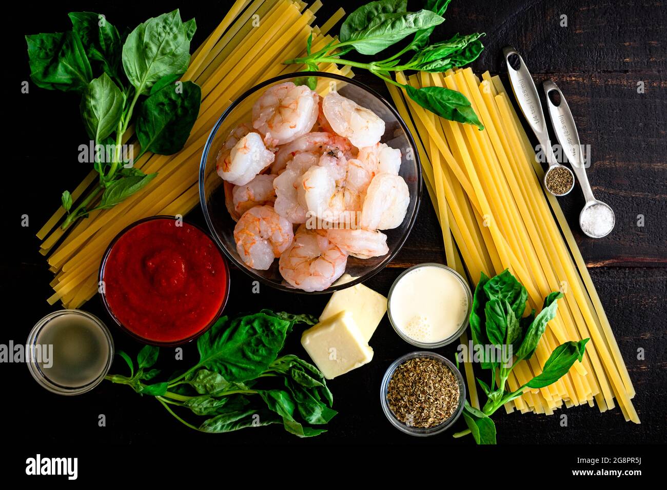 Garnelen und Pasta in Tomatensahnesauce Zutaten: Rohe Garnelen, Fettuccine Nudeln und andere Zutaten für Pasta und Tomatensahnesauce Stockfoto