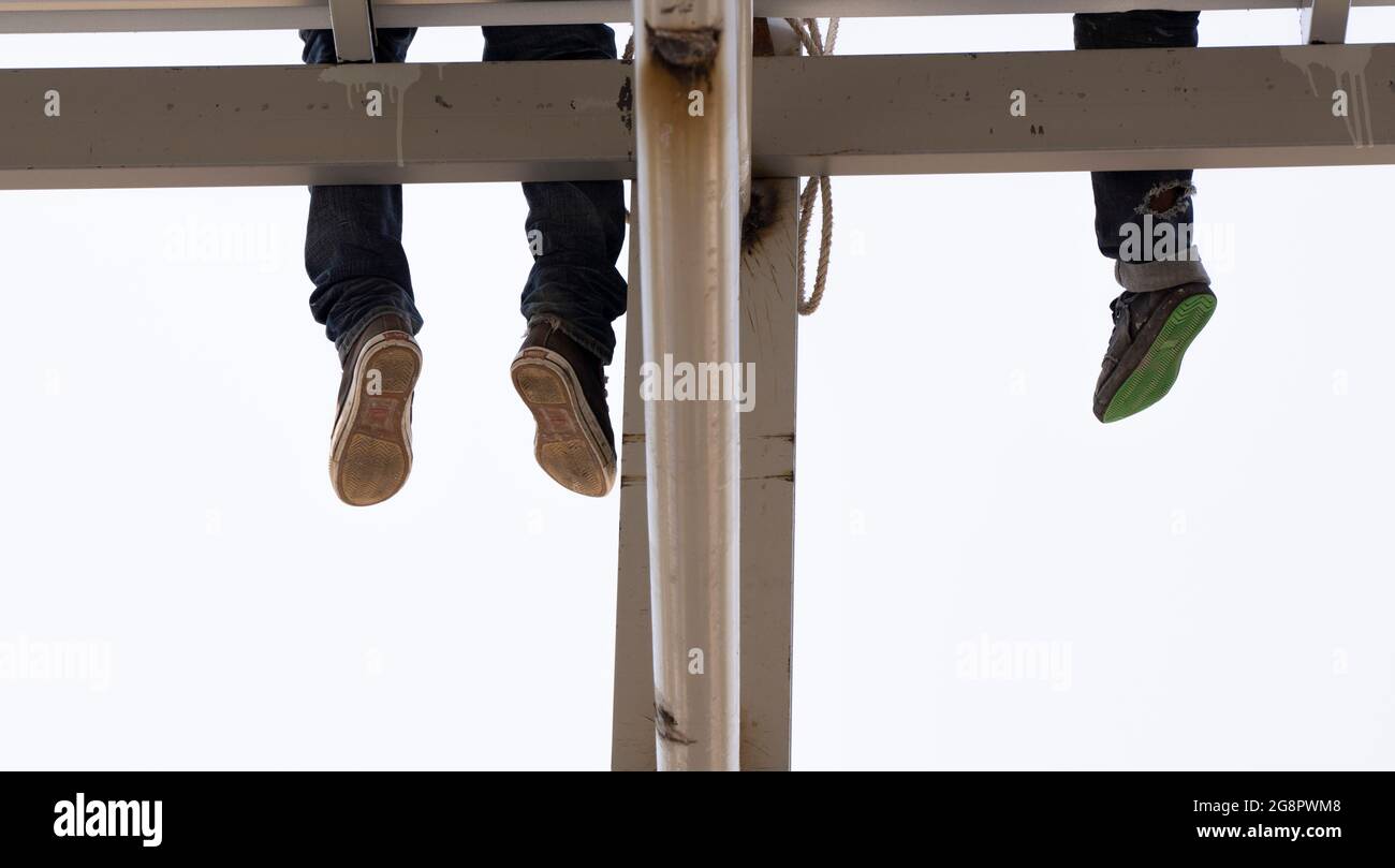 Zwei Männer drei Beine auf dem Dach. Stockfoto