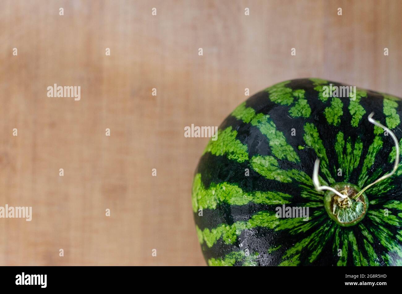 Eine frische, reife Wassermelone auf einem Holzbrett. Fruchtkonzept zum sommerlichen Essen Stockfoto