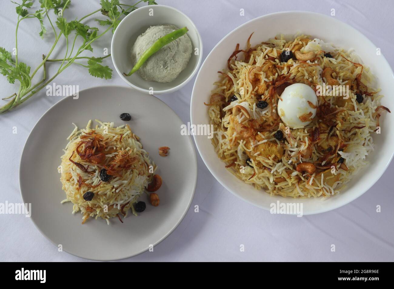 Hausgemachtes Huhn biriyani serviert mit Stachelbeerpickel. Gedämpfter Basmati-Reis, geschichtet mit würziger Soße aus entbeintem Huhn auf Joghurtbasis, karamellisiert Stockfoto