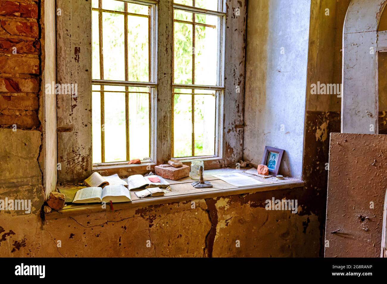 Im Inneren einer alten verlassenen Kirche in Lettland, Galgauska, Ikone und Kerzen auf der Fensterbank Stockfoto
