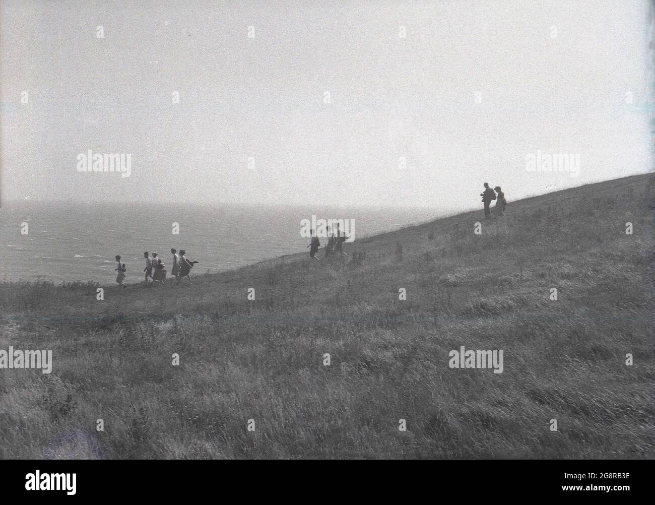 Die fünfziger Jahre, historisch, Menschen gehen auf der grasbewachsenen Landzunge bei Beachy Head, in der Nähe von Eastbourne, East Sussex, England, Großbritannien. Beachy Head ist die höchste kalkfarbene Meeresklippe in Großbritannien und ein berühmter Ort für Spaziergänge mit herrlichem Blick auf den Ärmelkanal. Stockfoto