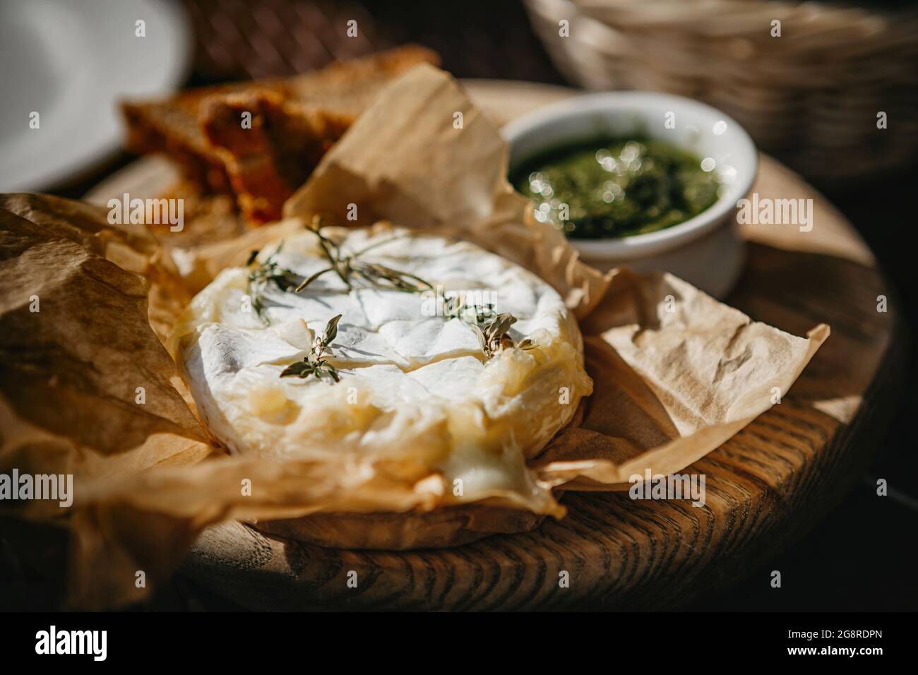 Im Ofen gebackener Camembert-Käse mit Rosmarin und Pesto-Sauce Stockfoto
