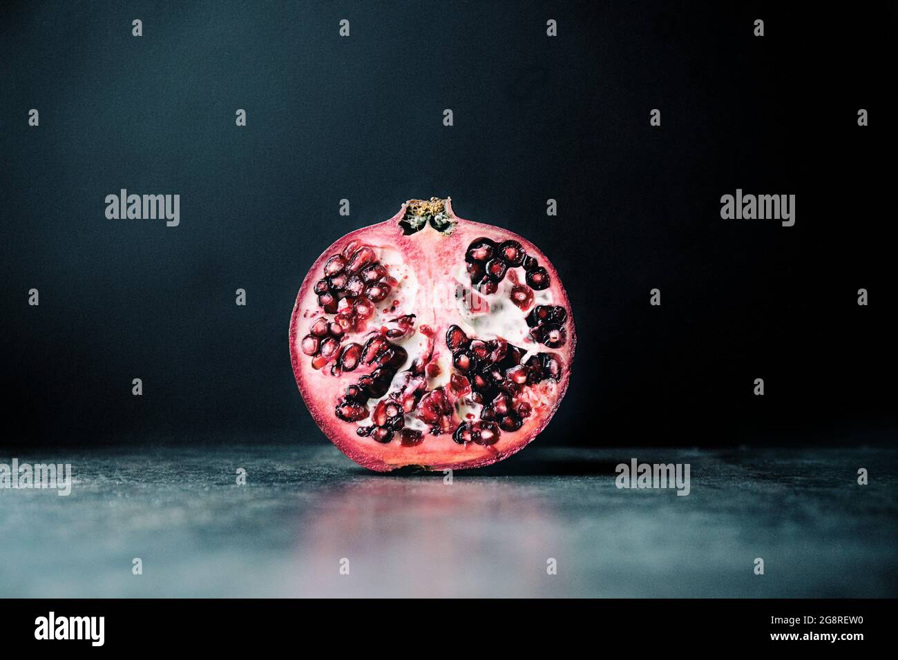 Nahaufnahme halber Granatapfel auf schwarzem Hintergrund Stockfoto